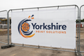 Heras fence banner printed with Yorkshire Print Solutions logo on a construction site fence